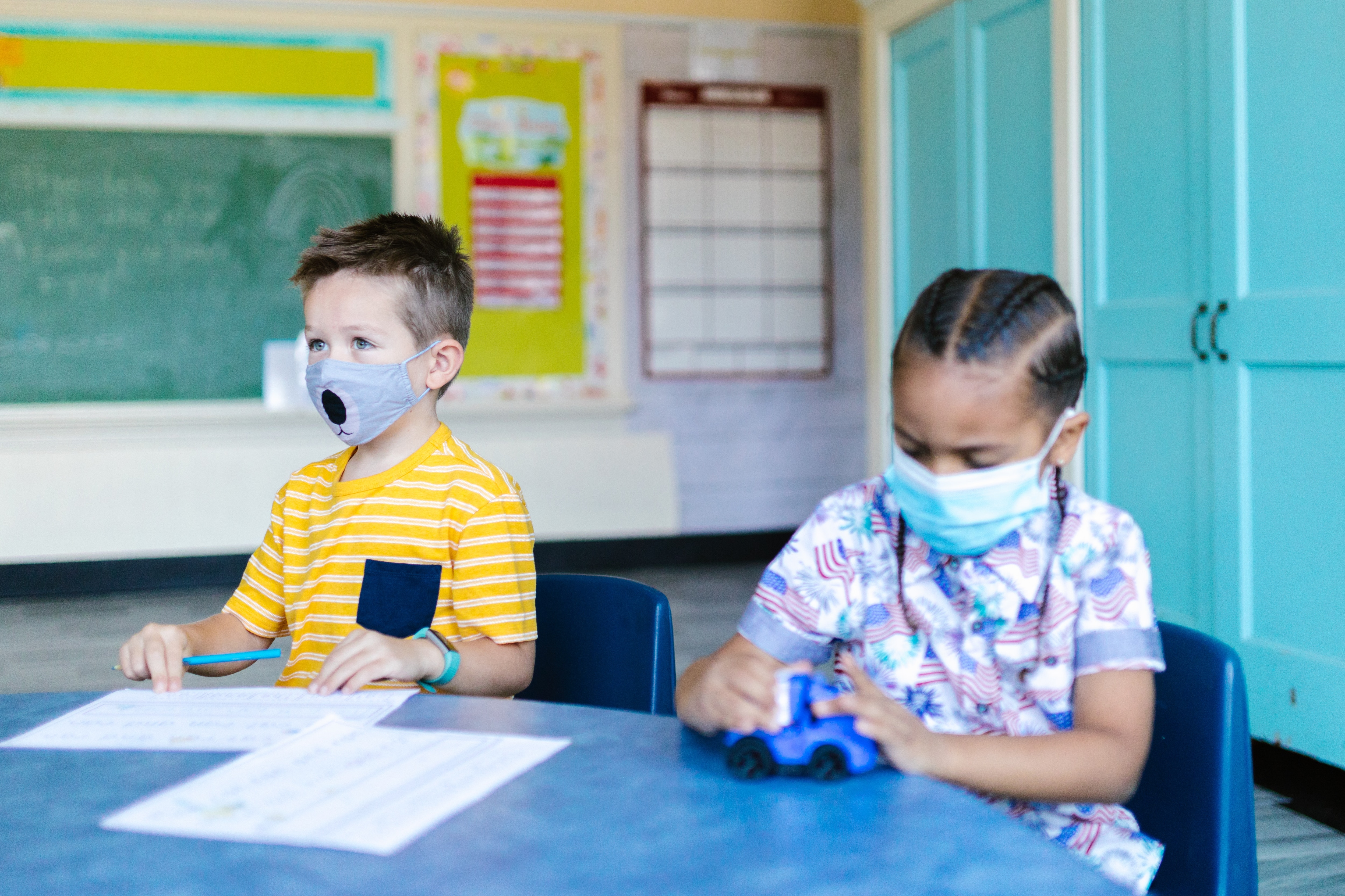 Children wear mask while studying in a classroom