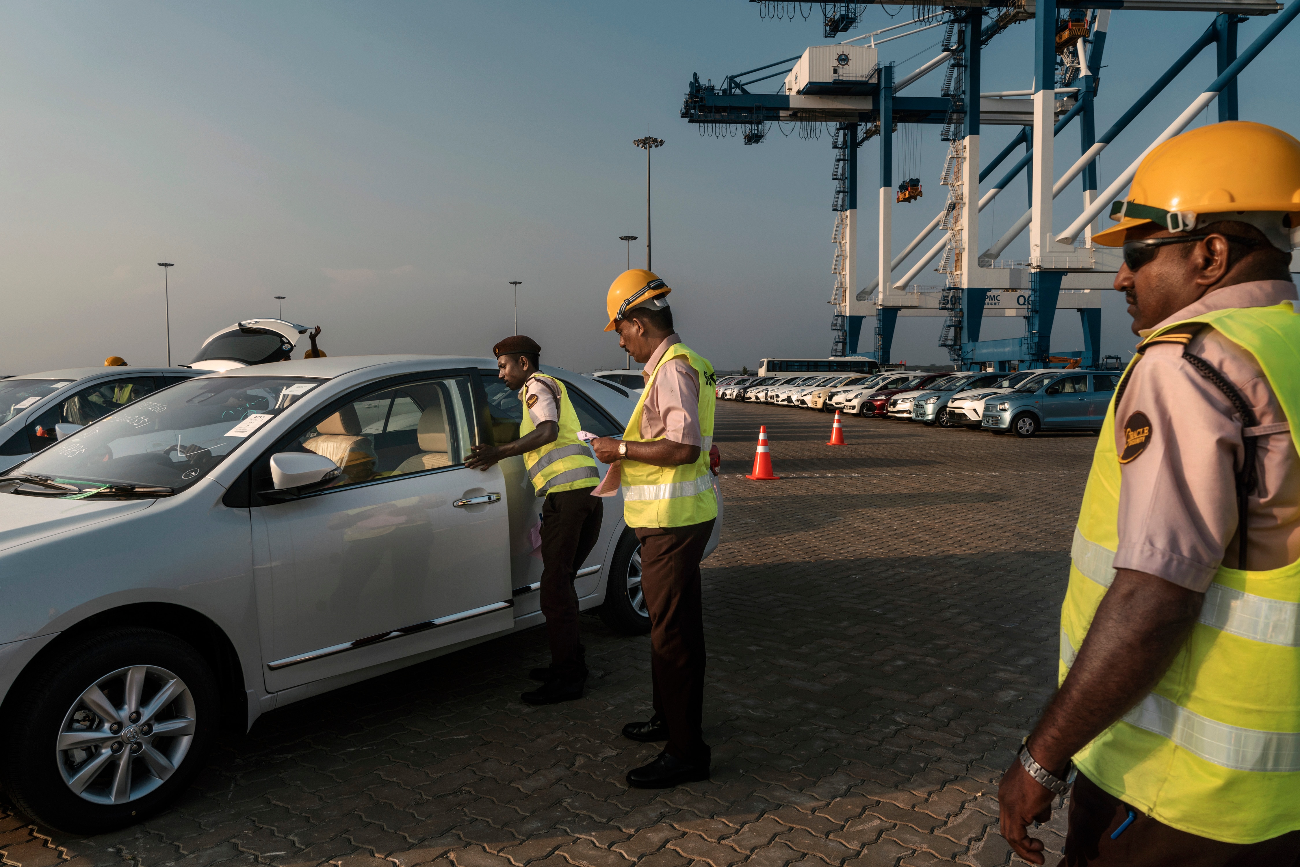 Sri Lankan workers process cars being unloaded from a ship at the Hambantota Port in Hambantota, Sri Lanka, March 5, 2018.