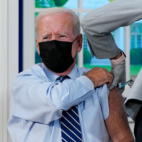 Joe Biden receives a COVID-19 booster shot during an event in the South Court Auditorium at the White House